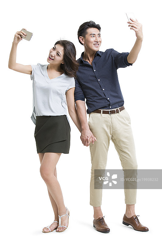 快乐的年轻情侣用手机自拍图片素材