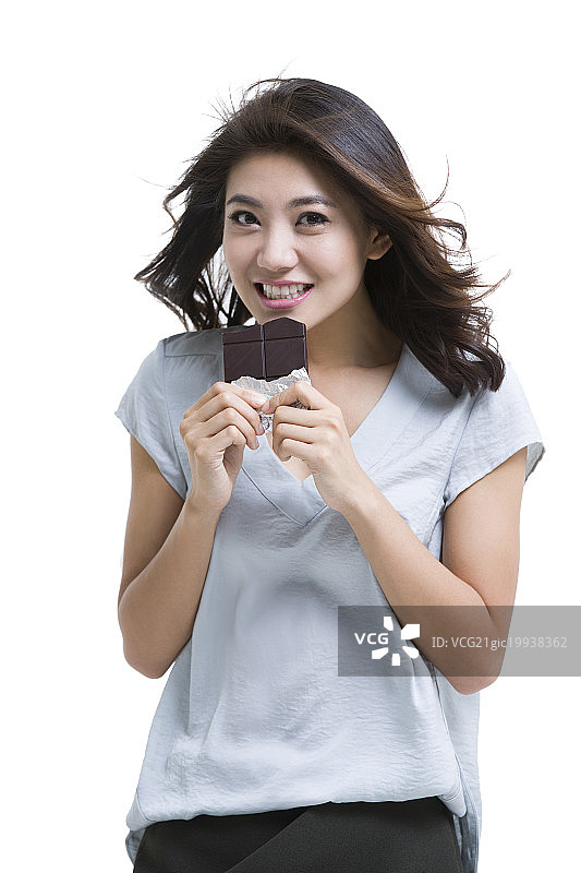 快乐的年轻女子吃巧克力图片素材