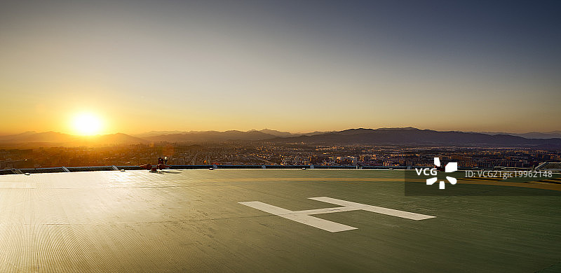 日落逆光下的直升机停机坪和北京城市远景图片素材