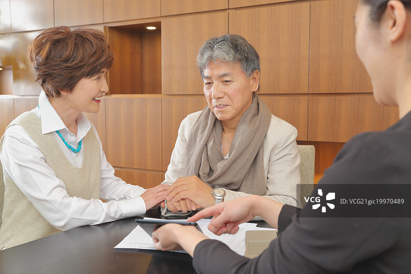 正在与顾问交谈的时尚日本老年夫妇图片素材