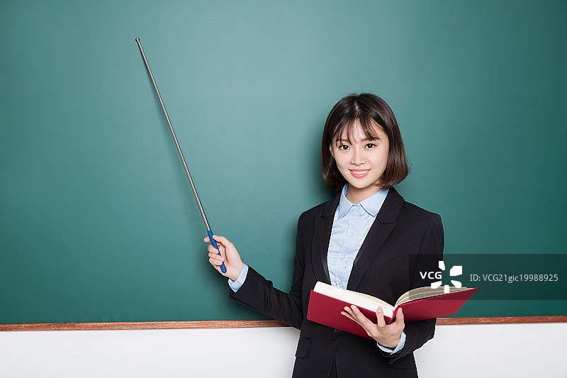 手持教棒的女教师,在黑板前图片素材