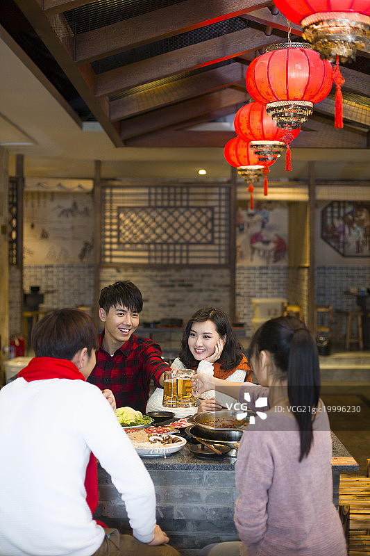 年轻朋友们在火锅店吃饭喝啤酒图片素材