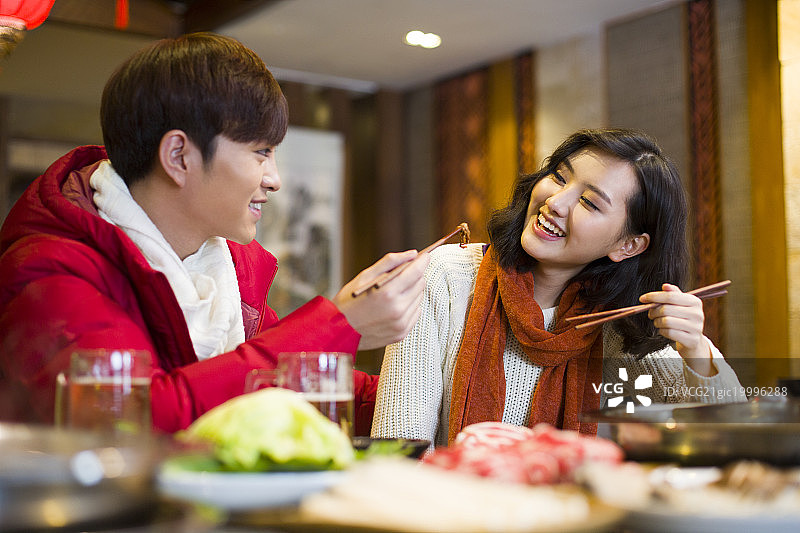 年轻情侣在火锅店吃饭图片素材