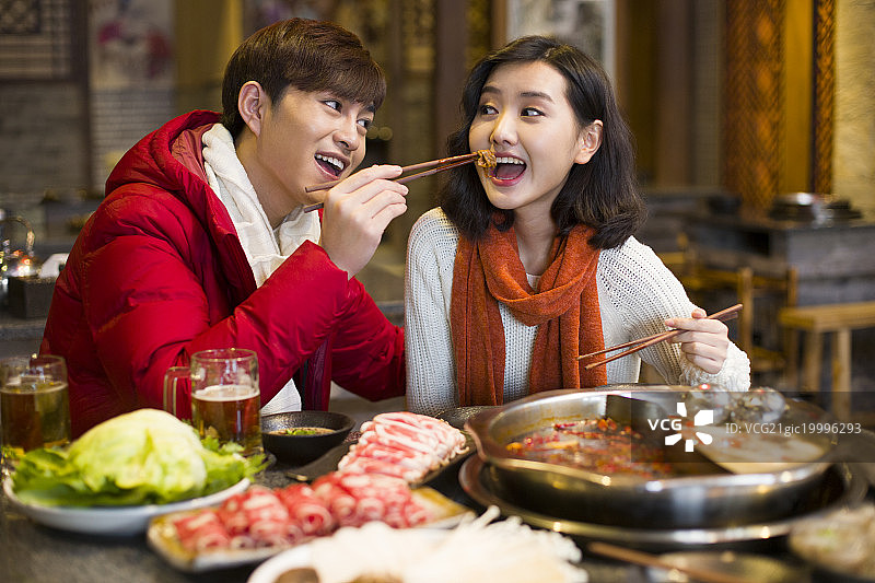 年轻情侣在火锅店吃饭图片素材