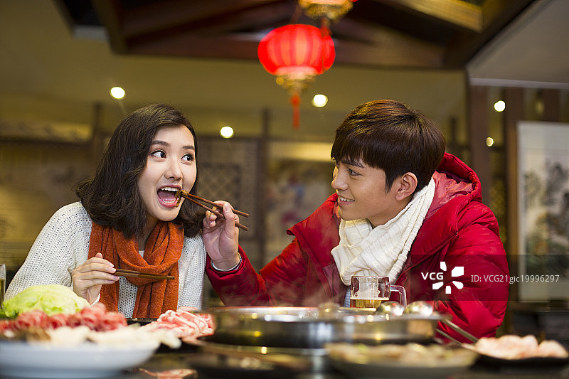 年轻情侣在火锅店吃饭图片素材