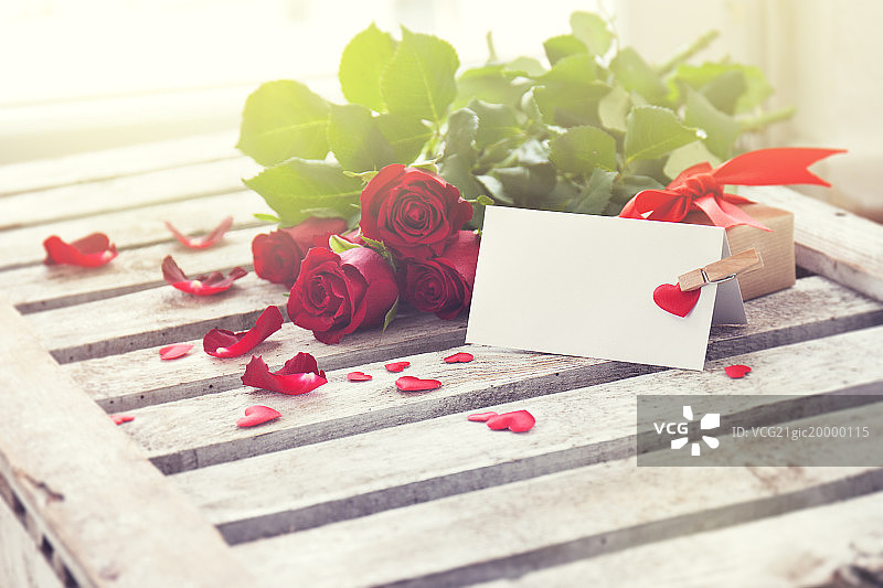 木质背景上的爱情信息特写，配有玫瑰，礼物图片素材