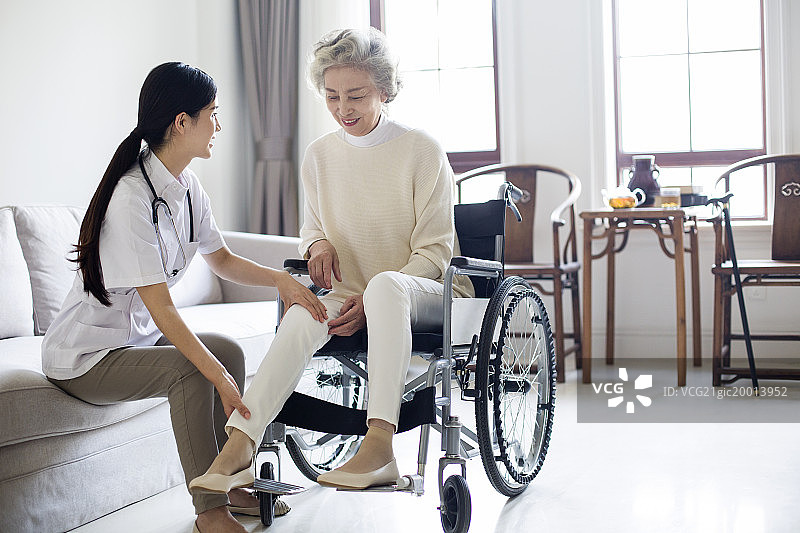 护工照顾坐着轮椅的老年女子图片素材