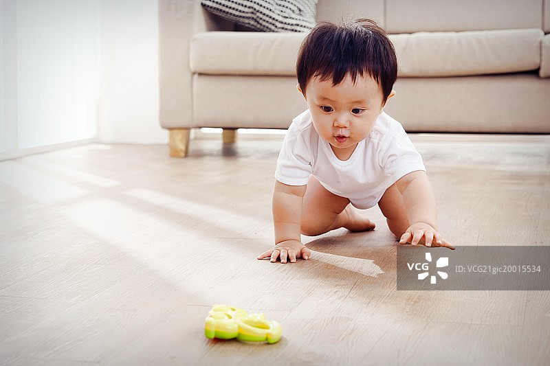 男婴儿在地板上玩耍图片素材