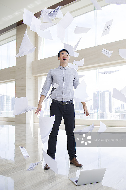 年轻商务男子把文件抛向空中图片素材