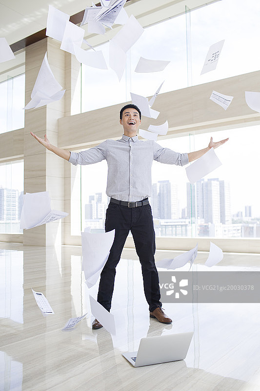 年轻商务男子把文件抛向空中图片素材