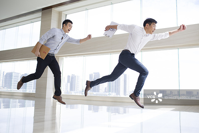 年轻商务男子在办公楼里奔跑图片素材