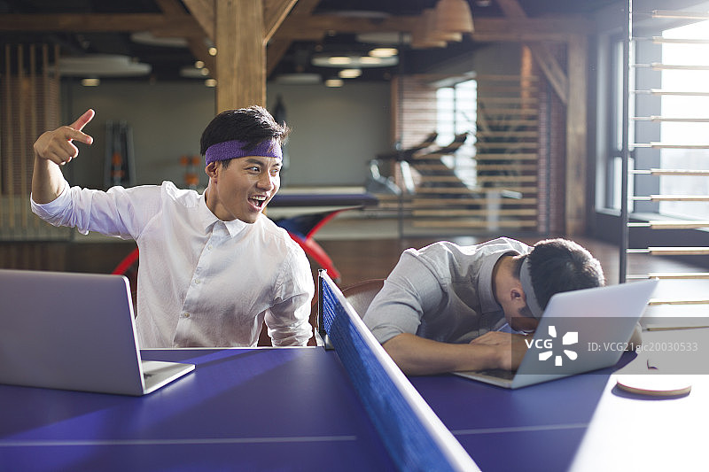 商务人士在乒乓球桌上使用笔记本电脑图片素材