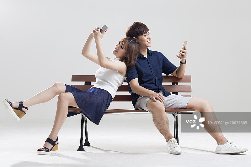 快乐的年轻情侣使用手机图片素材