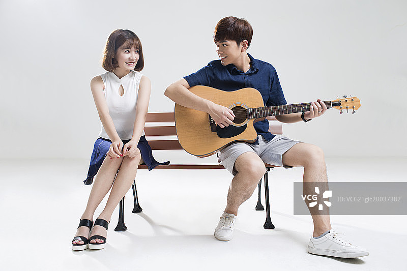 年轻男子为女友弹奏吉他图片素材
