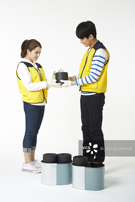 身穿志愿者马甲的男女运送煤砖图片素材