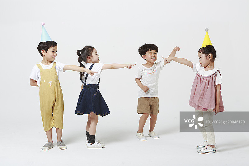 孩子们指向戴生日帽的女孩图片素材