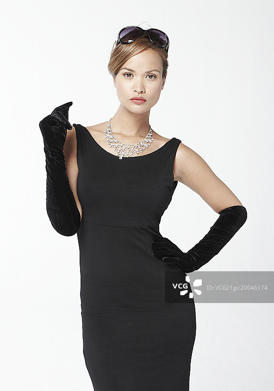 戴着太阳镜的黑衣女子凝视着镜头图片素材