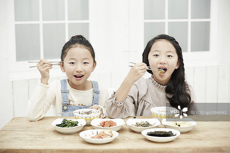 餐桌前快乐的双胞胎姐妹图片素材