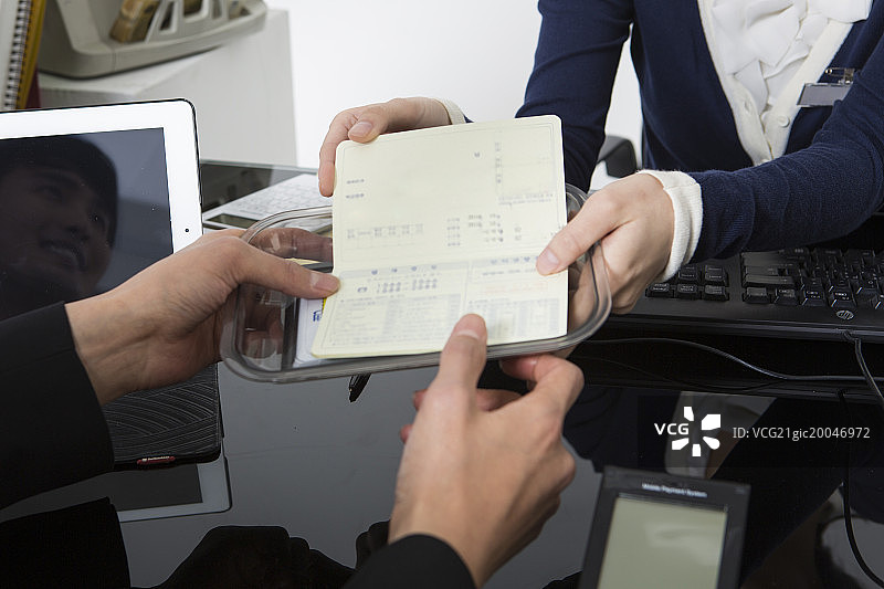 银行柜员递过银行存折图片素材