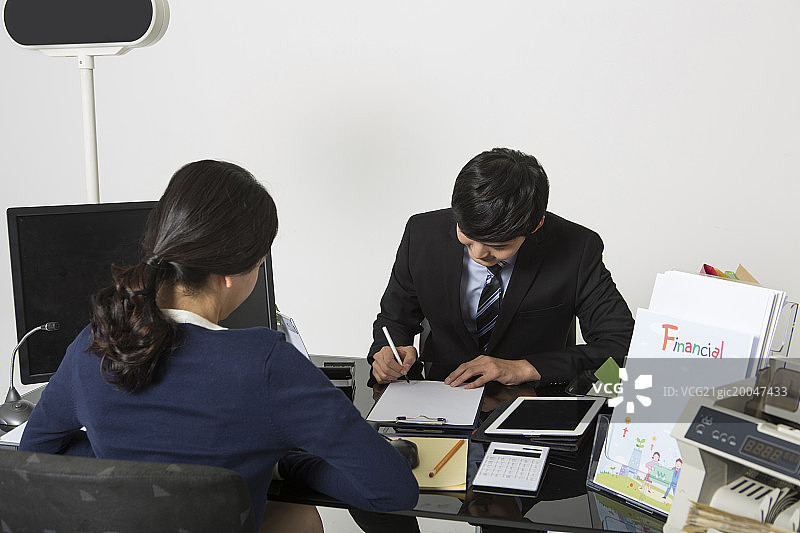 男商人在银行柜台填写表格图片素材