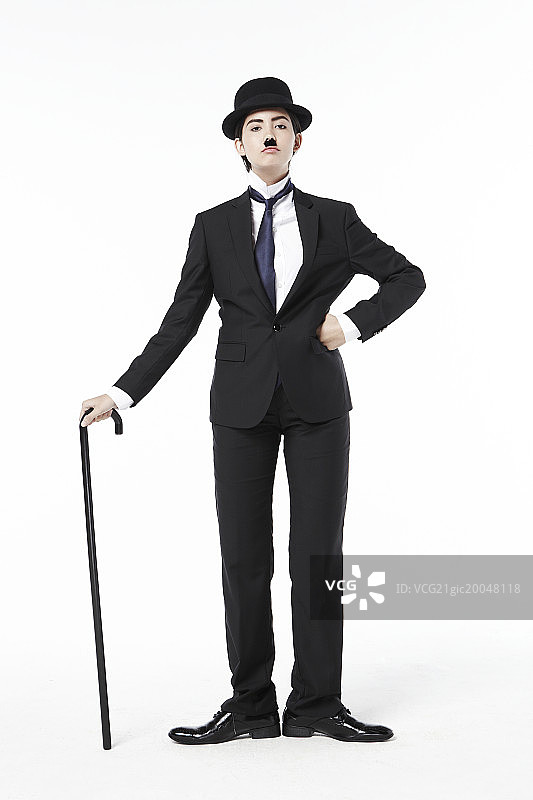 女人打扮成查理·卓别林手持拐杖图片素材