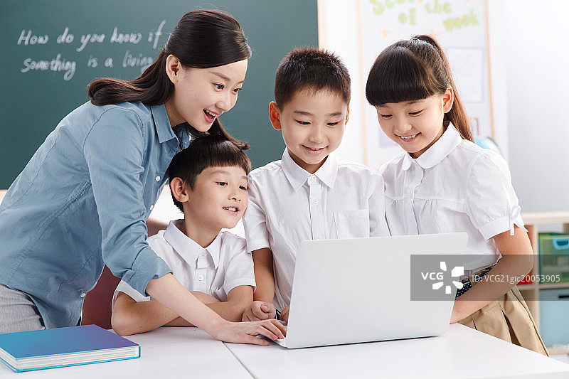 教师和小学生在教室里使用电脑图片素材