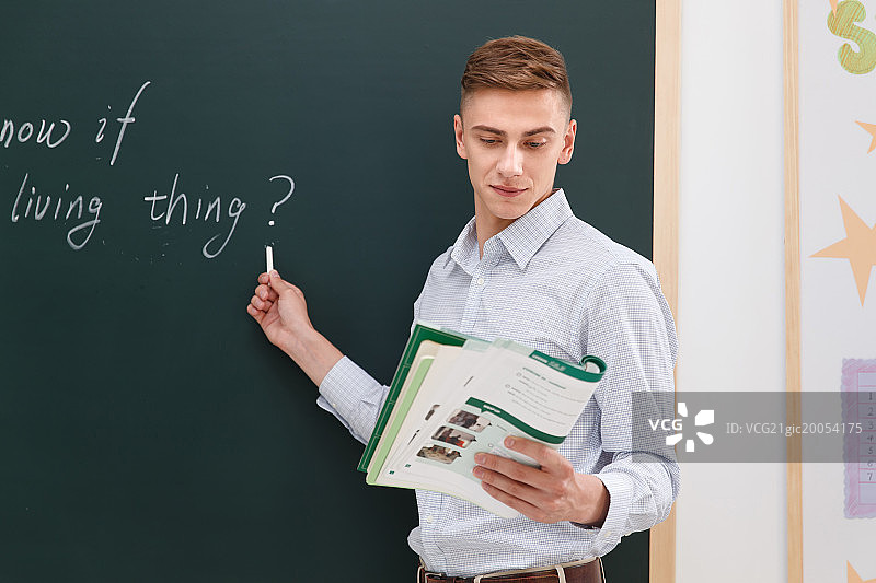 老师站在教室的黑板前图片素材