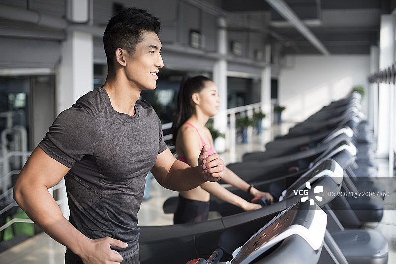 年轻情侣在健身房健身图片素材