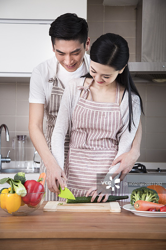 青年夫妇在厨房做饭图片素材