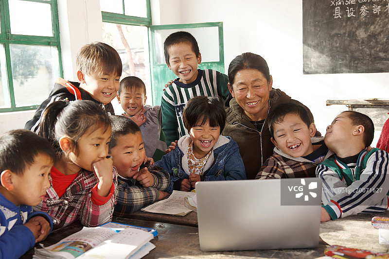 乡村女教师和小学生在使用电脑图片素材