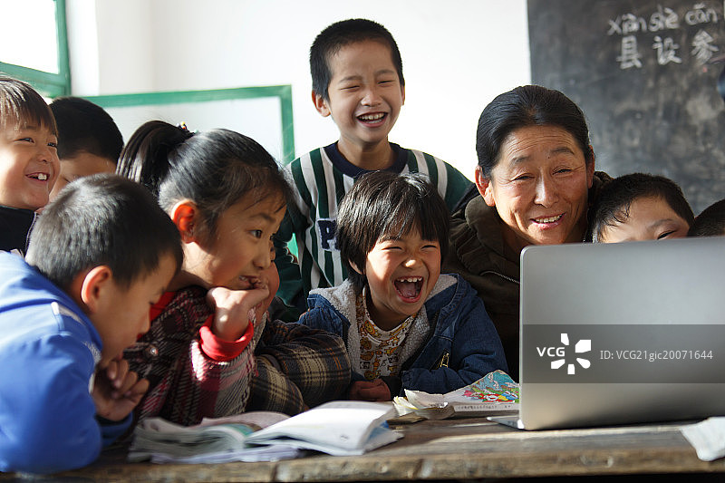 乡村女教师和小学生在使用电脑图片素材