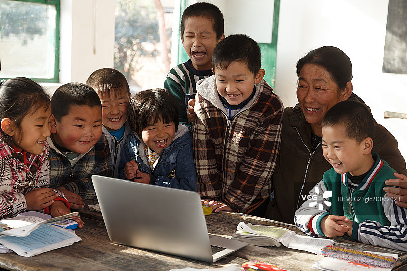 乡村女教师和小学生在使用电脑图片素材