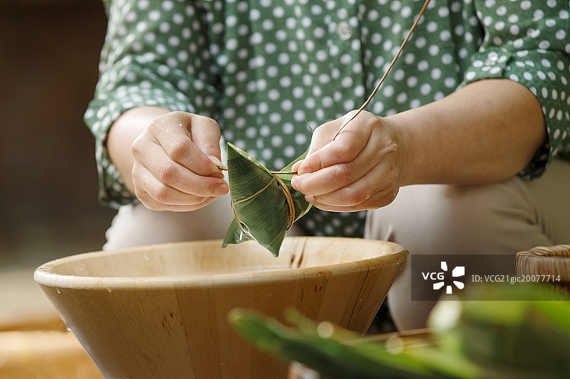 中年女人在包粽子图片素材