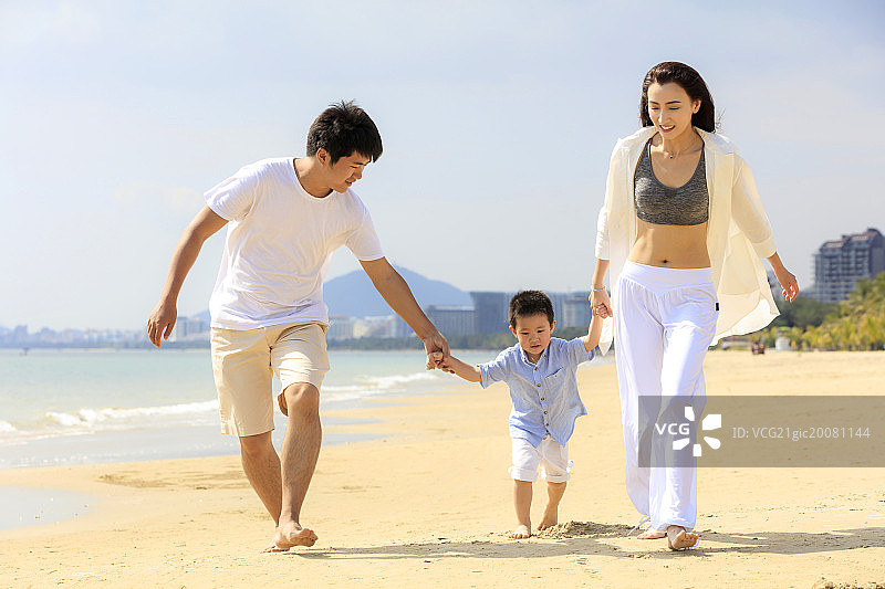 一家三口在海滩散步图片素材