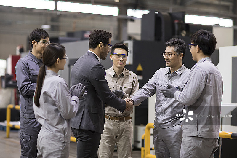 商务男士和工程师在工厂握手图片素材