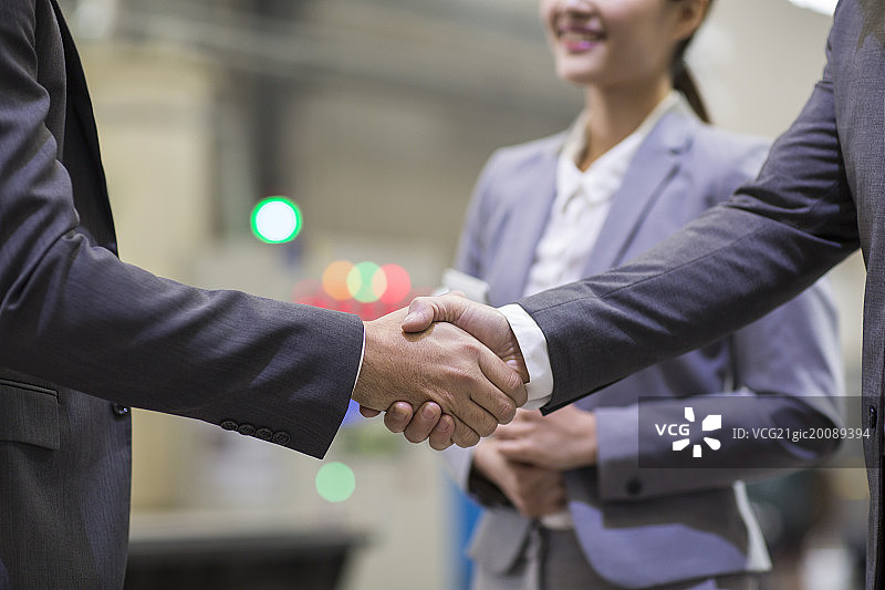 商务人士在工厂握手图片素材