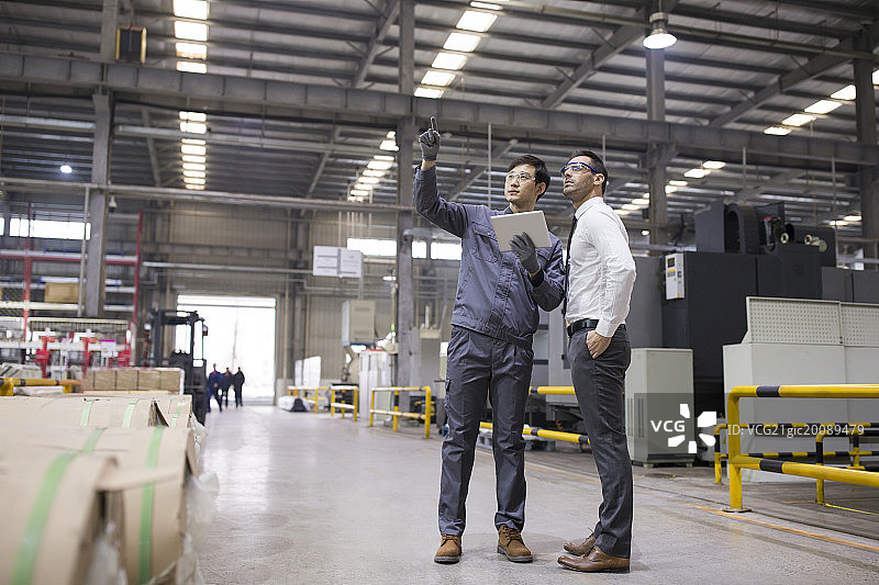 商务男士和工程师在工厂讨论工作图片素材