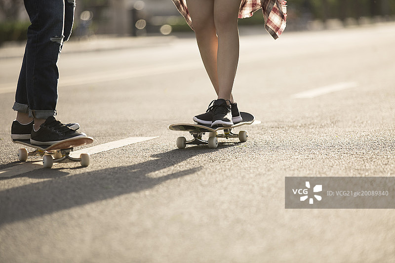 户外玩滑板的情侣图片素材