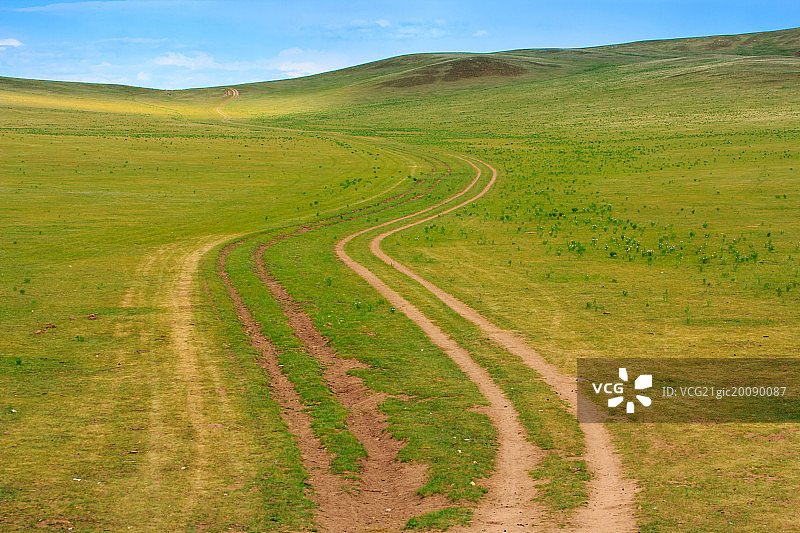 蜿蜒的车辙穿过草原图片素材