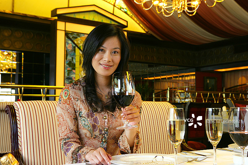 年轻女士在酒店餐厅拿葡萄酒肖像图片素材