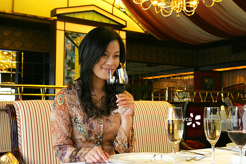 年轻女士在酒店餐厅拿葡萄酒肖像图片素材