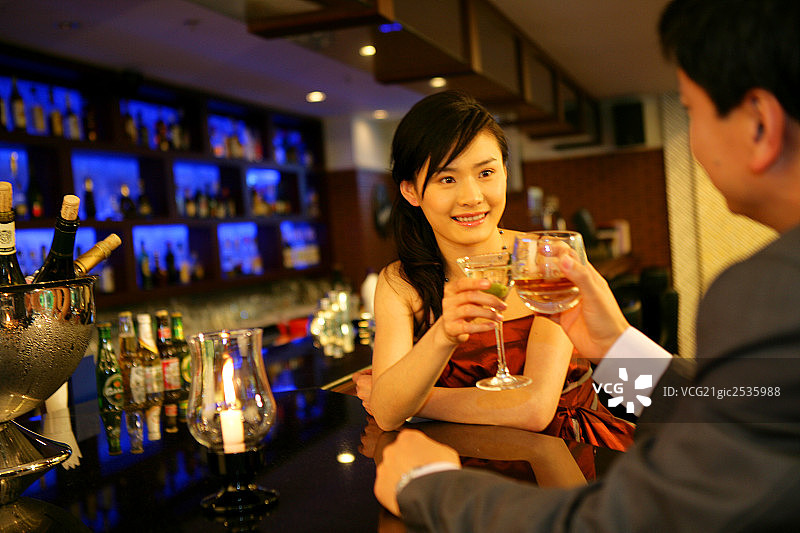 一对男女在酒店酒吧碰杯图片素材