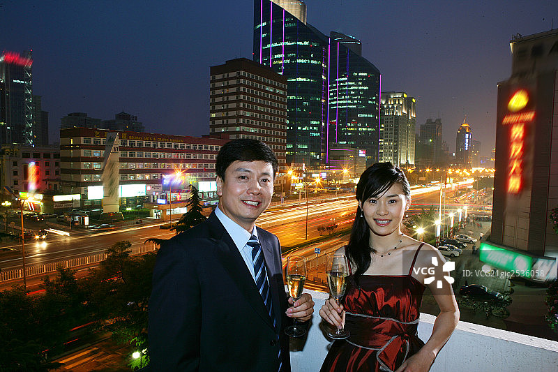 一对男女在都市夜景下饮酒图片素材