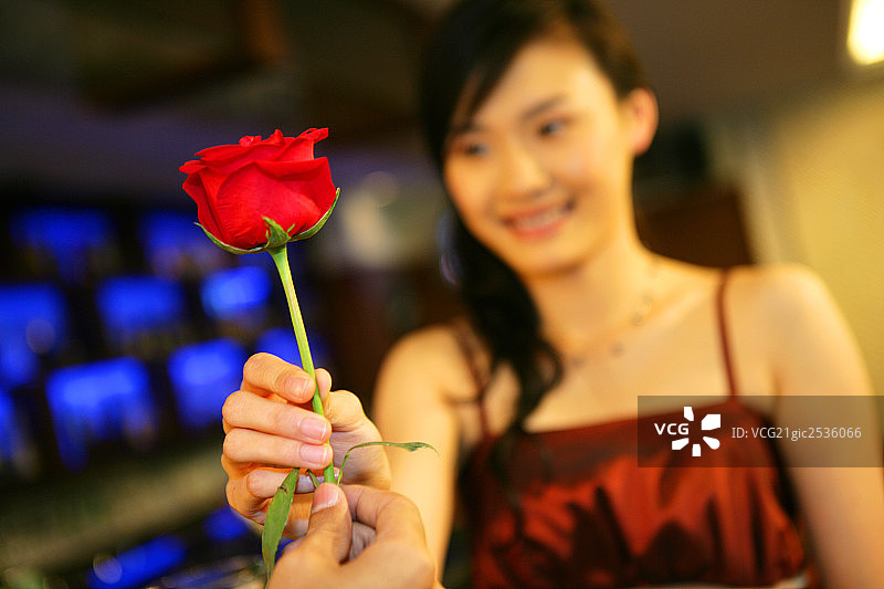 年轻女士在酒店酒吧收到玫瑰花图片素材