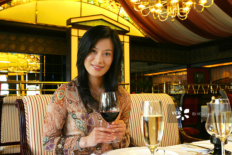 年轻女士在酒店餐厅拿葡萄酒肖像图片素材