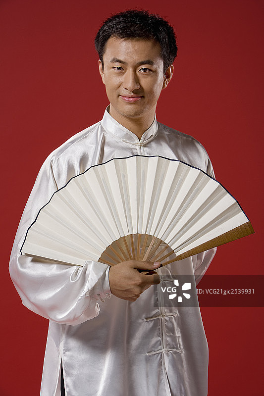 一位年轻人手拿一把扇子图片素材