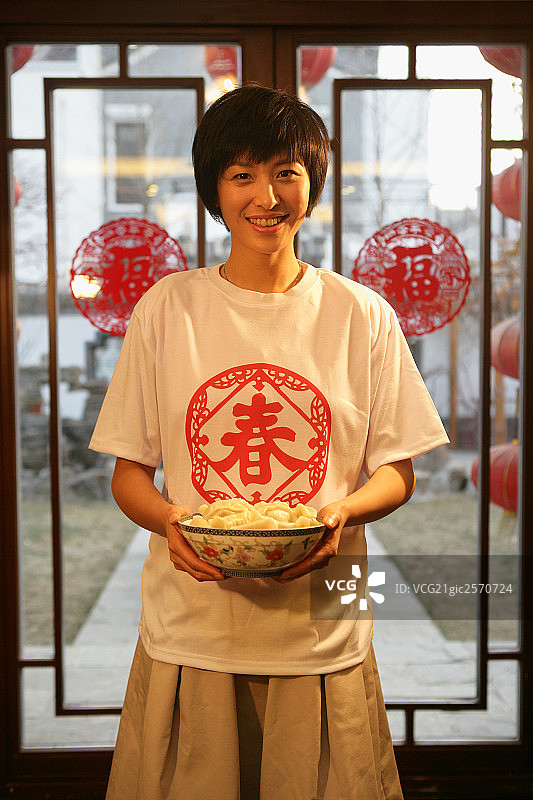 中国年轻女人手端一碗水饺图片素材