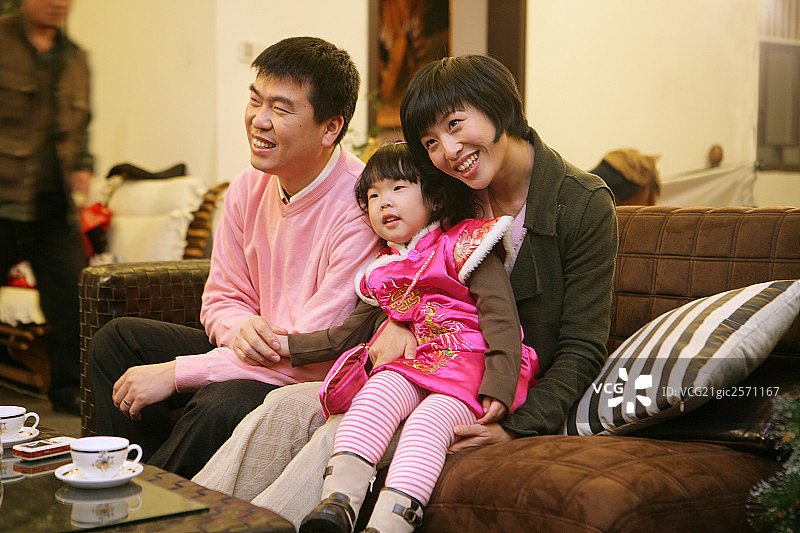 中国年轻夫妇和孩子一起看电视图片素材