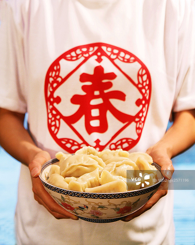 中国年轻女人手端一碗水饺图片素材