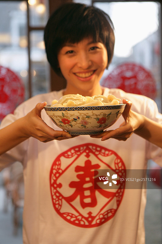 中国年轻女人手端一碗水饺图片素材